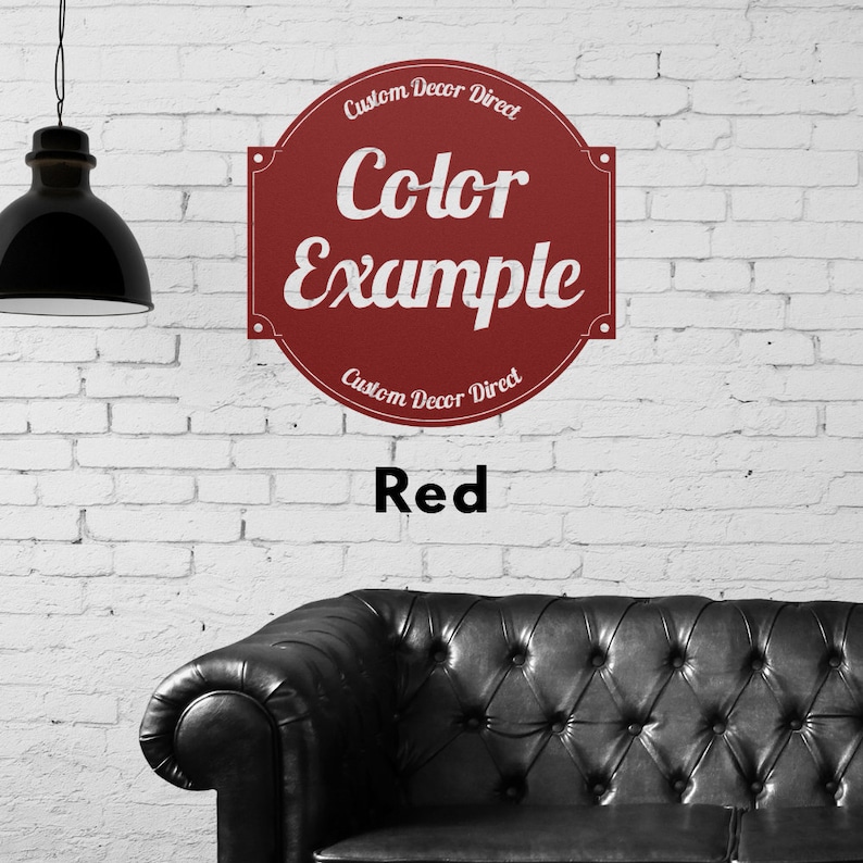 May include: A red circle sign with white text that reads "Custom Decor Direct" and "Color Example" with the word "Red" below the sign. The sign is on a white brick wall with a black leather couch in the foreground.