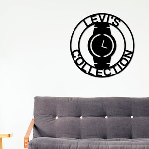 May include: Black metal wall art featuring a watch with the text "Levi's Collection" around it.