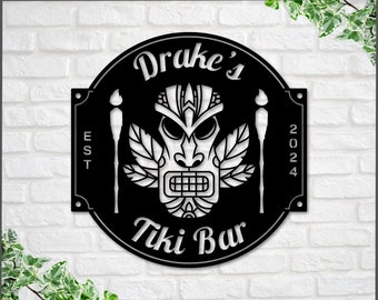 May include: Black metal tiki bar sign with the text "Drake's Tiki Bar" and the year "2024" with a tiki mask design.