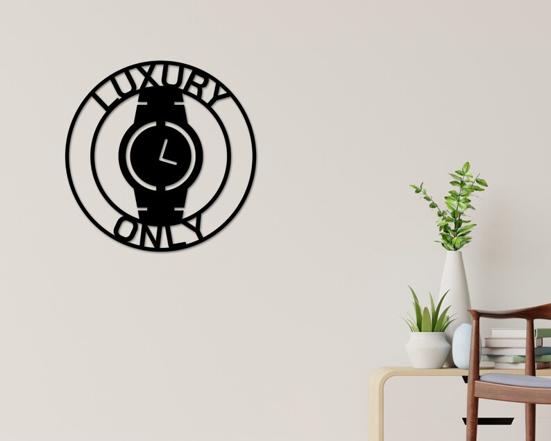 May include: Black metal wall decor with a circle design featuring a watch face and the words "Luxury Only".