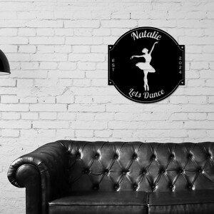 May include: Black metal sign with a white silhouette of a ballerina, the text "Natalie" at the top, "Lets Dance" at the bottom, and "EST 2024" on the sides.