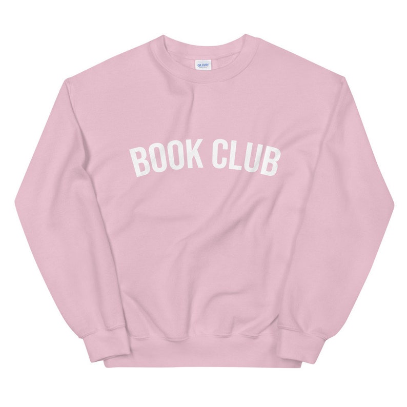 May include: A pink sweatshirt with the text "BOOK CLUB" in white letters.
