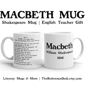 May include: White ceramic mug with a black Shakespeare quote from Macbeth on one side and the title "Macbeth" by William Shakespeare with the year 1606 on the other side.