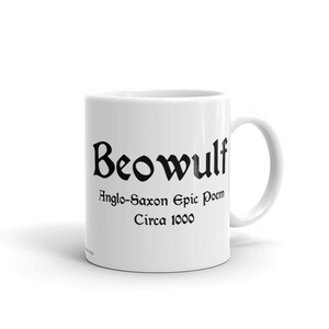 K&ouml;nnte beinhalten: Wei&szlig;e Keramiktasse mit einer schwarzen Aufschrift, die "Beowulf Anglo-Saxon Epic Poem Circa 1000" lautet.