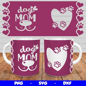 May include: Two white ceramic mugs with pink handles. One mug features the text "dog mom" with a paw print design. The other mug features a heart with paw prints inside. Both mugs have a pink background with a border of hearts and paw prints.