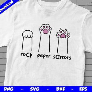 May include: White t-shirt with a graphic of three cat paws representing rock, paper, scissors. The text "rock paper scissors" is written below the paws.
