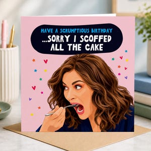 May include: A square greeting card with a light pink background featuring a cartoon illustration of a person with wavy brown hair eating with a silver spoon. The text reads: HAVE A SCRUMPTIOUS BIRTHDAY ...SORRY I SCOFFED ALL THE CAKE.