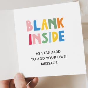 以下が含まれることがあります： カラフルな文字で「BLANK INSIDE」と書かれた白いグリーティングカード。その下に「AS STANDARD TO ADD YOUR OWN MESSAGE」と書かれています。カードは開かれており、空白の内側が明らかになっています。