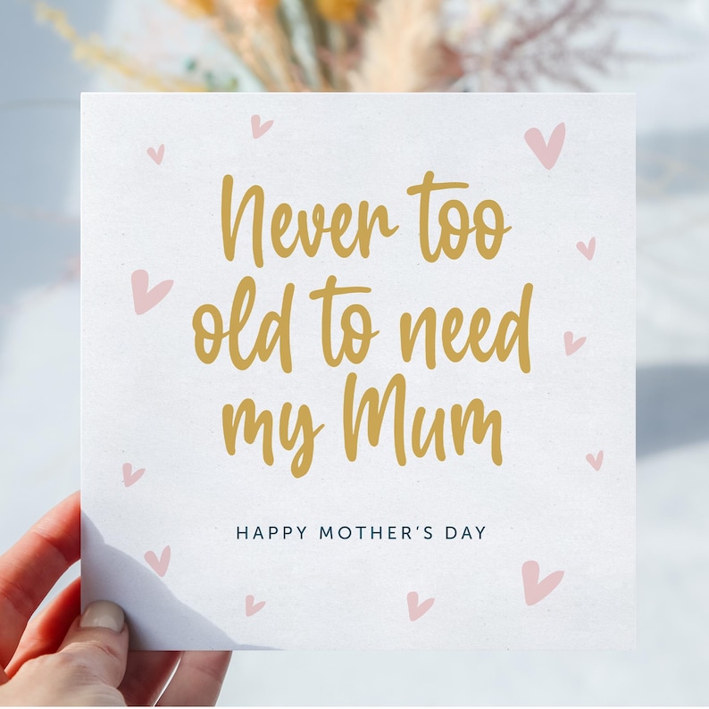 May include: A white card with pink hearts and gold lettering that reads "Never too old to need my Mum" and "Happy Mother's Day".