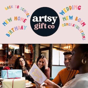 May include: A group of friends celebrating with a card that says "30". The card is gold and white with a glittery design. The friends are sitting at a table in a restaurant. The card is from artsy gift co.
