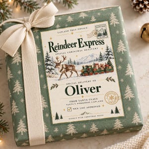 May include: A square gift box wrapped in sage green paper with a white pine tree pattern and a cream-colored ribbon. The center label reads Reindeer Express, Special Christmas Delivery to Oliver, from Santa Claus, Santa's Workshop, Lapland.