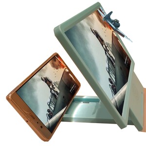 May include: A light blue phone screen magnifier with a smartphone and a miniature airplane. The screens display a war scene. The magnifier has a stand to hold the phone and screen.