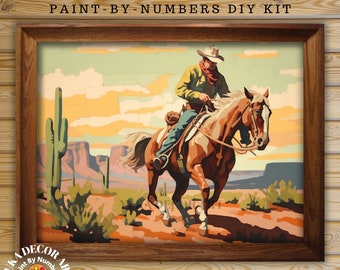 Könnte beinhalten: Vintage-Style Malen-nach-Zahlen DIY-Kit mit einem Cowboy, der auf einem Pferd durch eine Wüstenlandschaft reitet. Das Bild zeigt einen Kaktus, Berge und einen Sonnenuntergang.