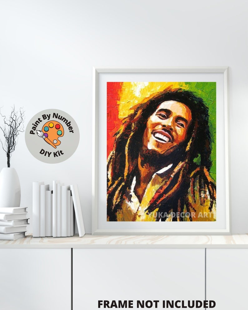 May include: Paint by numbers kit featuring a portrait of Bob Marley with a colorful background. The kit includes paints, brushes, and a canvas.