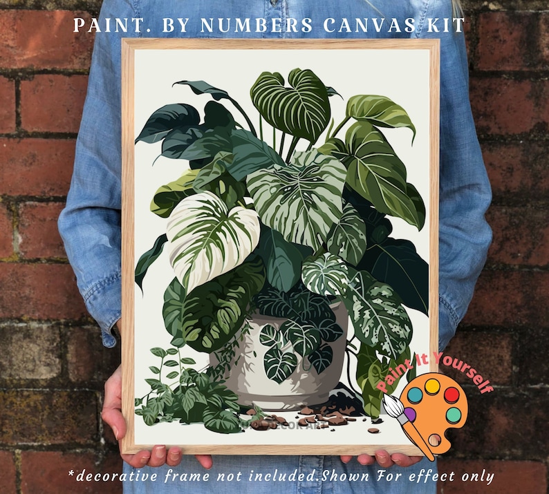 Op de afbeelding: Een paint-by-numbers canvas kit met een gedetailleerde illustratie van weelderige groene planten in een witte pot. Het kunstwerk bevat verschillende tinten groen en wit, met de tekst "PAINT. BY NUMBERS CANVAS KIT" bovenaan. De tekst "Paint it Yourself" is ook zichtbaar.