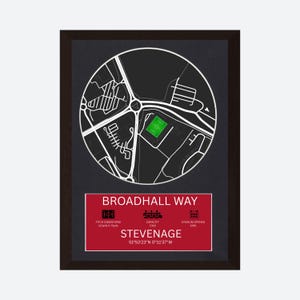 May include: A framed print featuring a circular map of Broadhall Way in Stevenage with a green football pitch. Below the map, a red rectangular box displays the text Broadhall Way, Stevenage, coordinates, and icons for pitch dimensions 110yds x 70yds, capacity 7,318, and stadium opened 1961.
