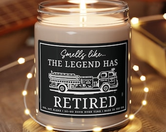 Può includere: Una candela di soia marrone con un'etichetta nera che recita "Smells like... THE LEGEND HAS RETIRED". L'etichetta presenta anche un'illustrazione in bianco e nero di un camion dei pompieri. La candela è appoggiata su un sottobicchiere di legno.