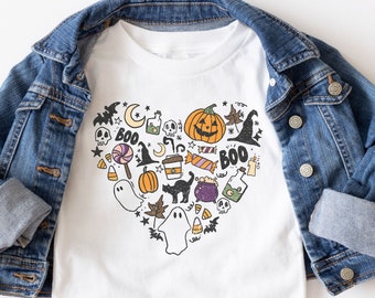 May include: White t-shirt with a heart-shaped design featuring various Halloween-themed illustrations, including ghosts, pumpkins, bats, candy corn, and the word "BOO".