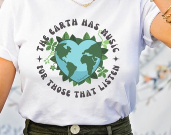 May include: White t-shirt with a green heart-shaped graphic of the Earth. The text "The Earth Has Music For Those That Listen" surrounds the graphic.