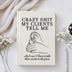 May include: A cream-colored notebook with the text "CRAZY SHIT MY CLIENTS TELL ME" in black. Below the text is a line drawing of hands applying nail polish. The bottom of the notebook reads "And now I have to take these secrets to the grave."
