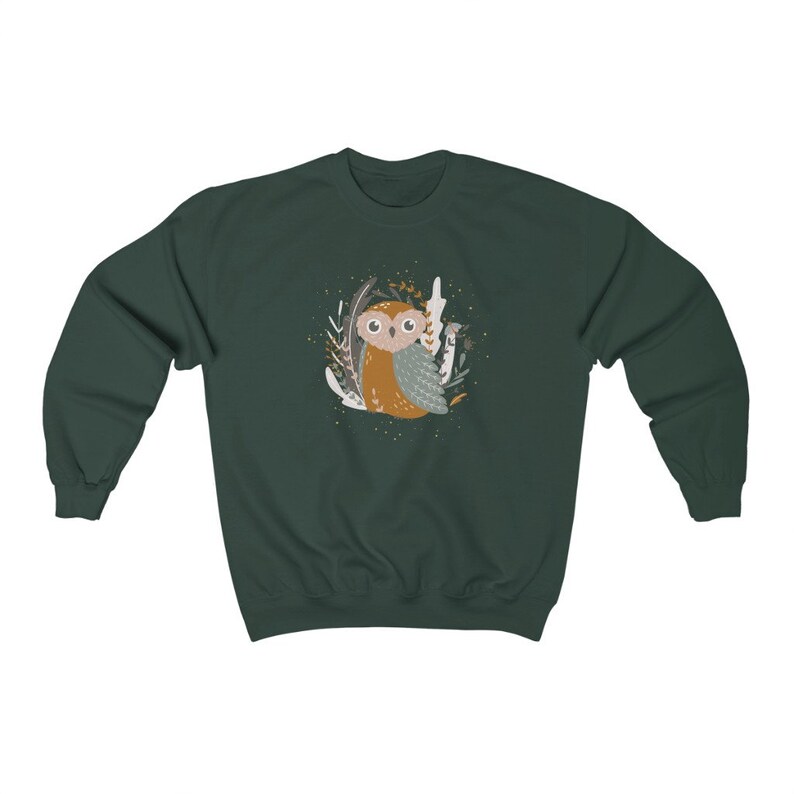 May include: A dark green sweatshirt with a cute cartoon owl in a forest setting. The owl is brown and gray with big eyes and is surrounded by leaves and branches.