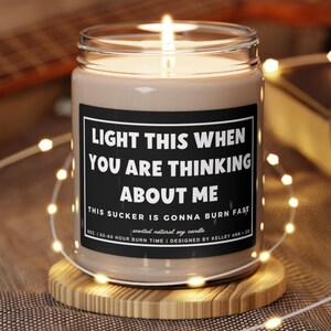 May include: A brown soy candle in a glass jar with a black label that reads "Light this when you are thinking about me. This sucker is gonna burn fast. Scented natural soy candle. 10 oz. | 50-60 hour burn time | Designed by Kelley Ann + Co."