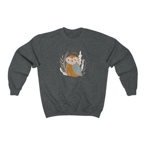 May include: A dark gray sweatshirt with a cartoon owl in a forest setting. The owl is brown and gray with a white belly and large eyes. The forest is depicted with brown branches and green leaves.