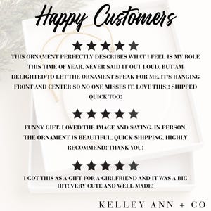 Peut inclure: Un ornement circulaire blanc en c&eacute;ramique avec une ficelle dor&eacute;e, pr&eacute;sent&eacute; dans une bo&icirc;te cadeau blanche. L'image affiche trois avis clients cinq &eacute;toiles avec du texte louant l'ornement, et la marque KELLEY ANN + CO en bas.