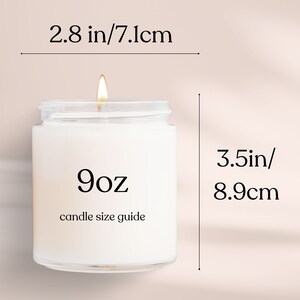 May include: A white candle in a clear glass jar with a black label that says "9oz candle size guide". The candle is lit and the jar is 8.9 cm tall and 7.1 cm wide.