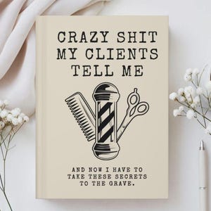 May include: A beige notebook with black text that reads CRAZY SHIT MY CLIENTS TELL ME and AND NOW I HAVE TO TAKE THESE SECRETS TO THE GRAVE. The center features a black graphic illustration of a hair comb, a barber pole, and hair scissors.