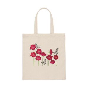 May include: A white canvas tote bag with a design of red flowers and white butterflies.