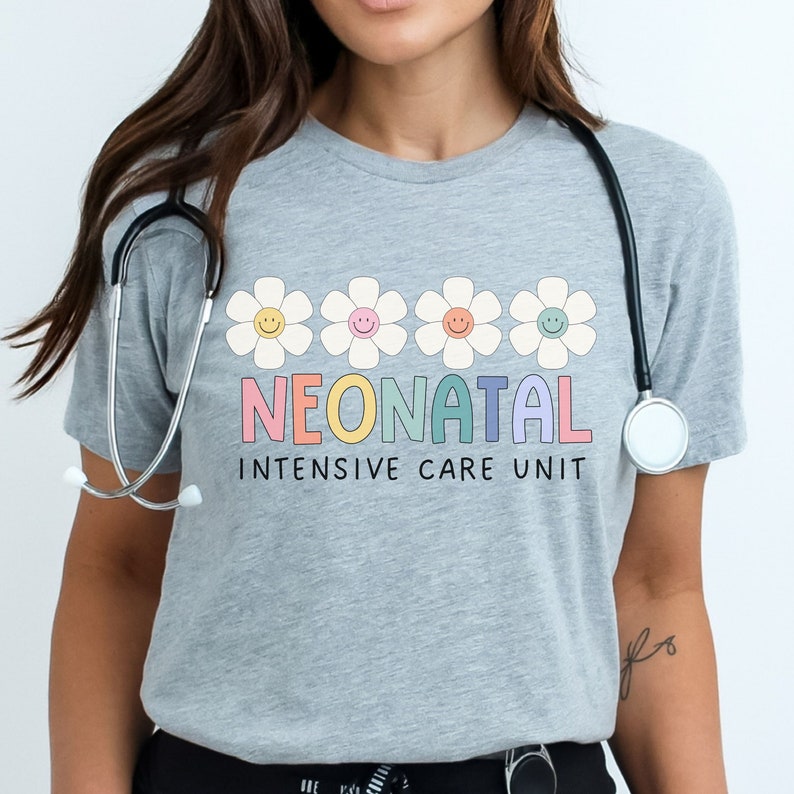 May include: A grey t-shirt with a row of five white daisies with yellow centers and smiling faces. The text "NEONATAL INTENSIVE CARE UNIT" is printed below the daisies in rainbow colors.