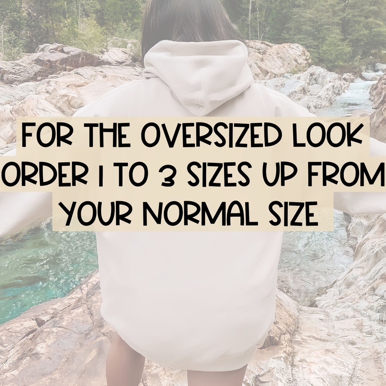May include: A person wearing a light beige oversized hoodie with the text "FOR THE OVERSIZED LOOK ORDER 1 TO 3 SIZES UP FROM YOUR NORMAL SIZE" printed on the front.