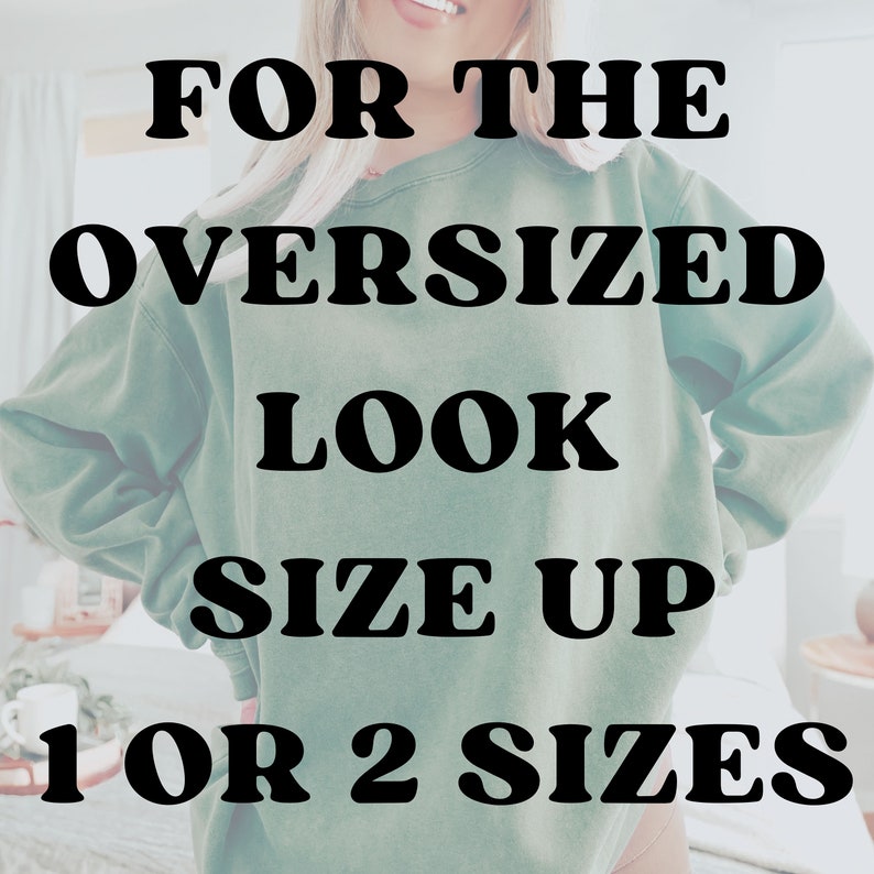 May include: A woman wearing a green oversized sweatshirt with the text "FOR THE OVERSIZED LOOK SIZE UP 1 OR 2 SIZES".