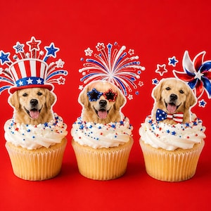 May include: Three cupcakes topped with white frosting and red, white, and blue sprinkles. Each cupcake features a golden retriever cutout. The first wears a patriotic top hat, the second wears star-shaped glasses, and the third wears a bow tie.