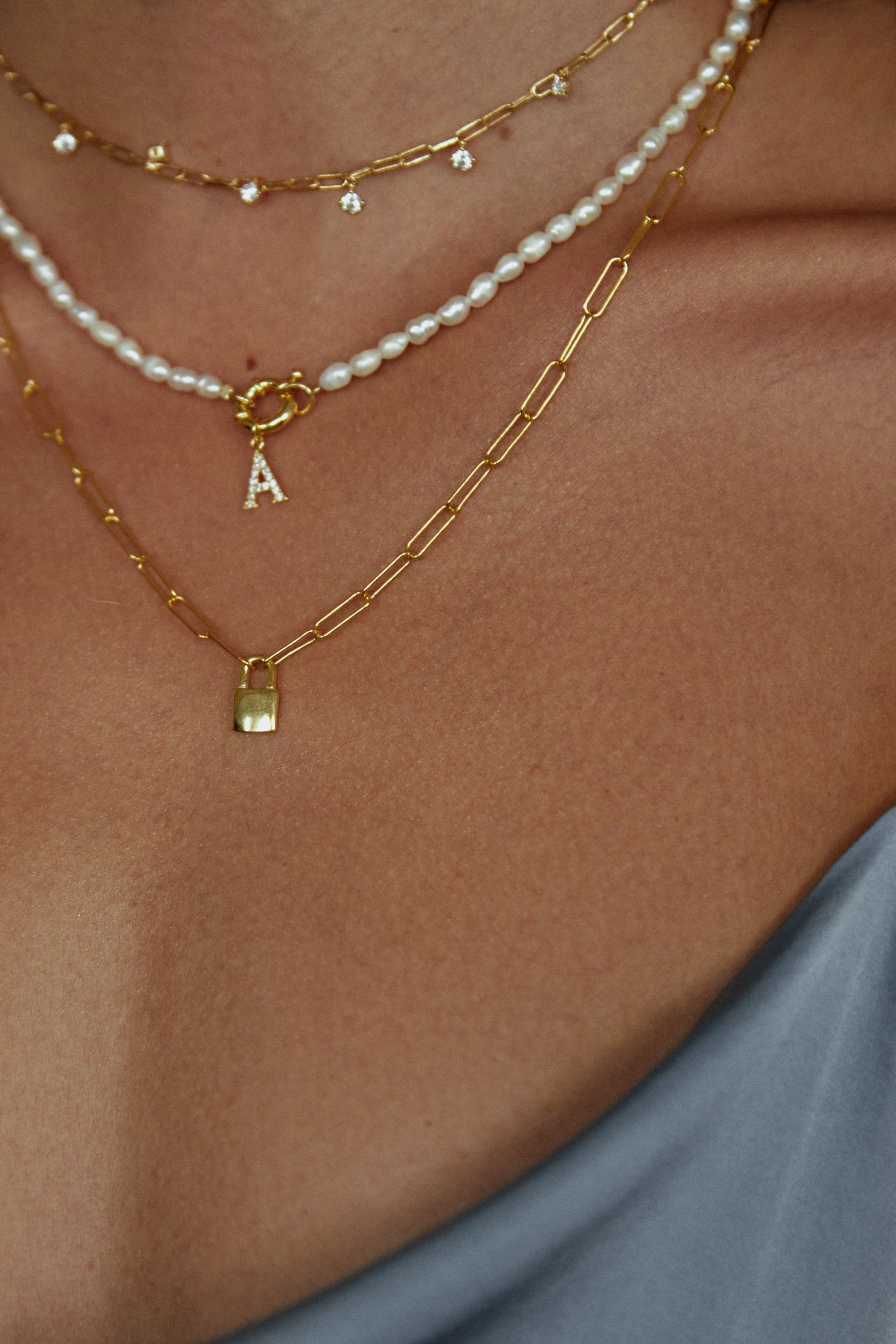 A guest wears pearls pendant necklaces from Vivienne Westwood, a