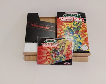 May include: A Teenage Mutant Ninja Turtles II: The Arcade Game Nintendo Entertainment System game cartridge, box, and instruction manual. The box is black with the Nintendo logo in red. The game cartridge is black with a clear plastic window showing the game's title card. The instruction manual is a colorful booklet with images of the Teenage Mutant Ninja Turtles.