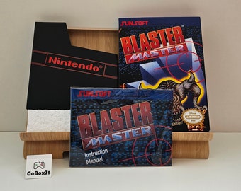 Może przedstawiać: Czarne pudełko na kartridż do gry Nintendo z napisem "Nintendo®" z przodu. Pudełko znajduje się obok instrukcji do gry wideo z tytułem "BLASTER MASTER" w czerwonym i niebieskim kolorze. Instrukcja ma niebieskie i czarne tło z czerwono-białym wzorem tarczy. Instrukcja ma również złotą pieczęć z napisem "Official Nintendo Seal".
