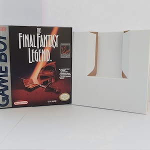May include: A white Game Boy game cartridge box with a red and black image of a sword and a treasure chest. The text on the box reads "The Final Fantasy Legend" and "Nintendo Game Boy".