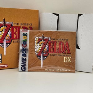 Peut inclure: Une cartouche de jeu Game Boy Color pour The Legend of Zelda: Link's Awakening DX, avec le livret d'instructions et la boîte. La boîte est brune avec une bordure dorée et présente le logo du jeu. La cartouche est dans un boîtier en plastique transparent.