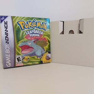 May include: A Game Boy Advance video game box for Pokémon LeafGreen Version. The box features a green and blue design with the Pokémon character Venusaur. Includes a Game Boy Advance Wireless Adapter.