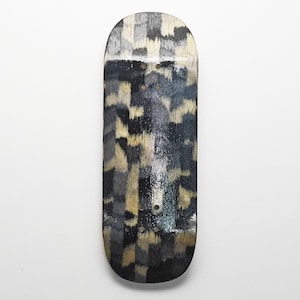 Puede incluir: Una tabla de fingerboard con un patrón repetitivo de estilo camuflaje en tonos negro, gris oscuro, gris claro y beige. La tabla de madera tiene un acabado liso y brillante e incluye ocho orificios pretaladrados para montar los ejes.