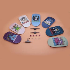 Pode incluir: Uma coleção de mini skates de dedo em várias cores, cada um com um gráfico de desenho animado único. O conjunto inclui trucks, rodas e outros acessórios para montagem. As pranchas apresentam designs com as palavras "Wrath", "Sloth" e "Greed".