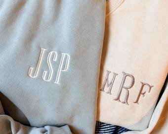 Può includere: Due felpe a girocollo, una verde salvia con lettere ricamate bianche JSP e una color crema con lettere ricamate marroni MRF. Entrambi i capi presentano maniche lunghe, polsini a coste e un classico design a pullover con monogramma.