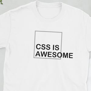 Pode incluir: Camiseta branca com um gráfico quadrado preto que diz "CSS IS AWESOME" em letras maiúsculas.
