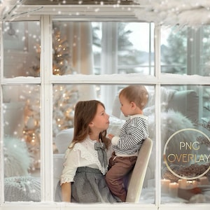 Puede incluir: Una escena invernal a través de un marco de ventana blanco, con nieve cayendo y ramas heladas. Dos niños se miran. Una superposición PNG es visible en la esquina inferior derecha. El fondo presenta un árbol de Navidad.