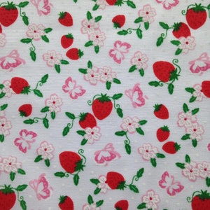 May include: White fabric with a repeating pattern of red strawberries, pink butterflies, and white flowers with green leaves.
