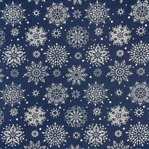 May include: A navy blue fabric with a white snowflake pattern. The snowflakes are of various sizes and are arranged in a repeating pattern.