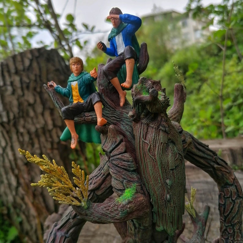 May include: Two figures, one in green and one in blue, are perched on a tree trunk with a rough, bark-like texture. The tree trunk is decorated with green moss and has a large, gnarled branch extending to the right.
