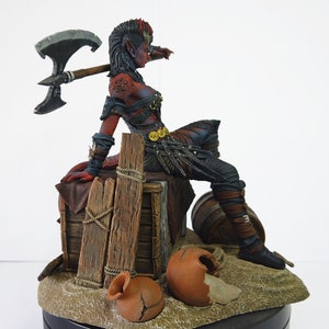 May include: A detailed figurine of a red-skinned fantasy character with a mohawk, resting on a wooden crate. The character holds a large axe and wears dark armor. The base includes a broken pot and a small barrel.